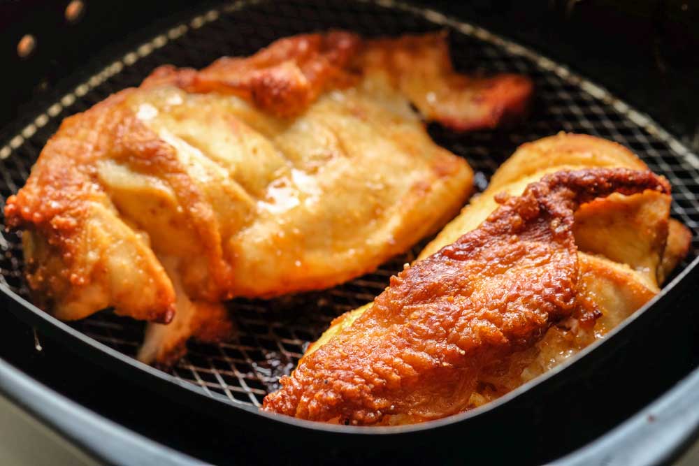 Golden brown chicken cooking in an Air Fryer