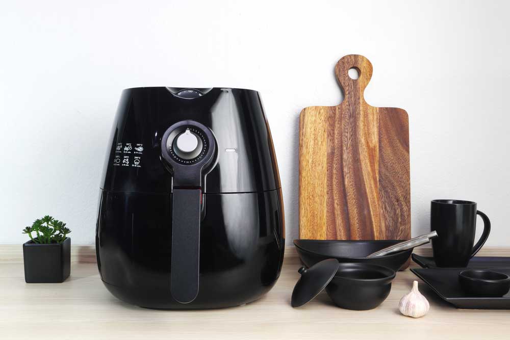 Air Fryer on counter with bowls and cutting board