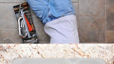 Man under sink with tools
