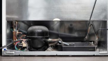 back view of a refrigerator with compressor and drip pan