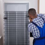 Man fixing coils on fridge