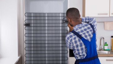 Man fixing coils on fridge