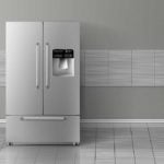 stainless steel fridge against a grey tiled wall