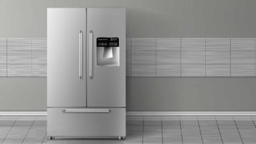 stainless steel fridge against a grey tiled wall