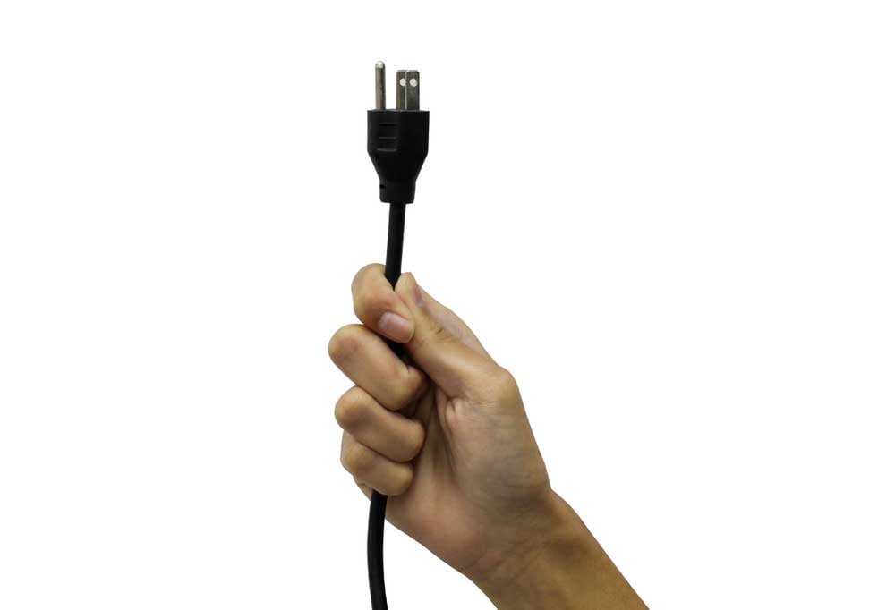 Hand holding an electrical plug