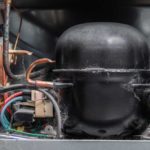 Close up of the back workings of a fridge