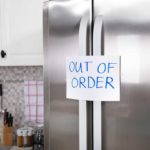 Fridge with sign on door saying "Out of Order"