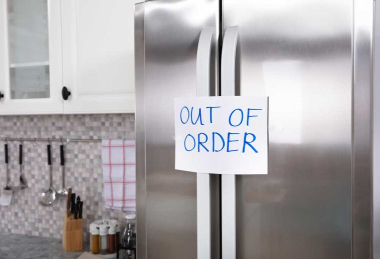 Fridge with sign on door saying "Out of Order"