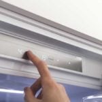 person resetting temperature on fridge control panel