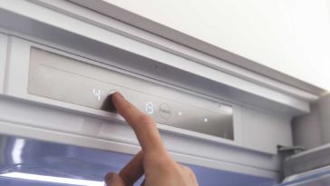 person resetting temperature on fridge control panel