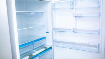 Fridge door open revealing glass shelves