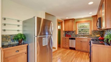 Wood themed kitchen with a stainless steel fridge