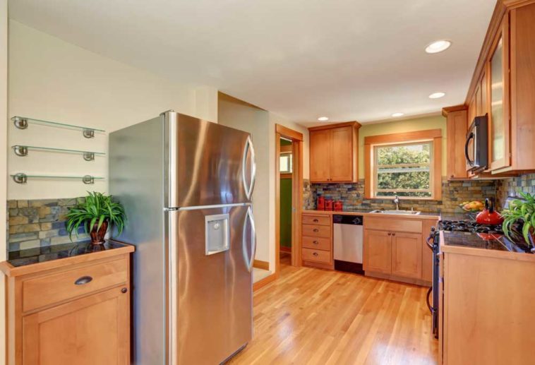 Wood themed kitchen with a stainless steel fridge