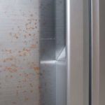 Close up of stainless steel fridge door with rust