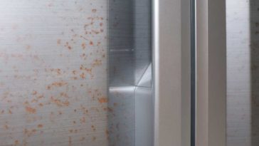 Close up of stainless steel fridge door with rust