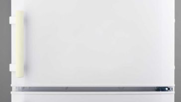 close up of a white fridge with a yellow door handle