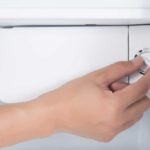 Hand turning dial to refrigerator thermostat