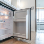 Empty mini fridge open under counter top