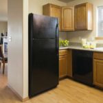 Black appliances in a kitchen with honey colored cabinets