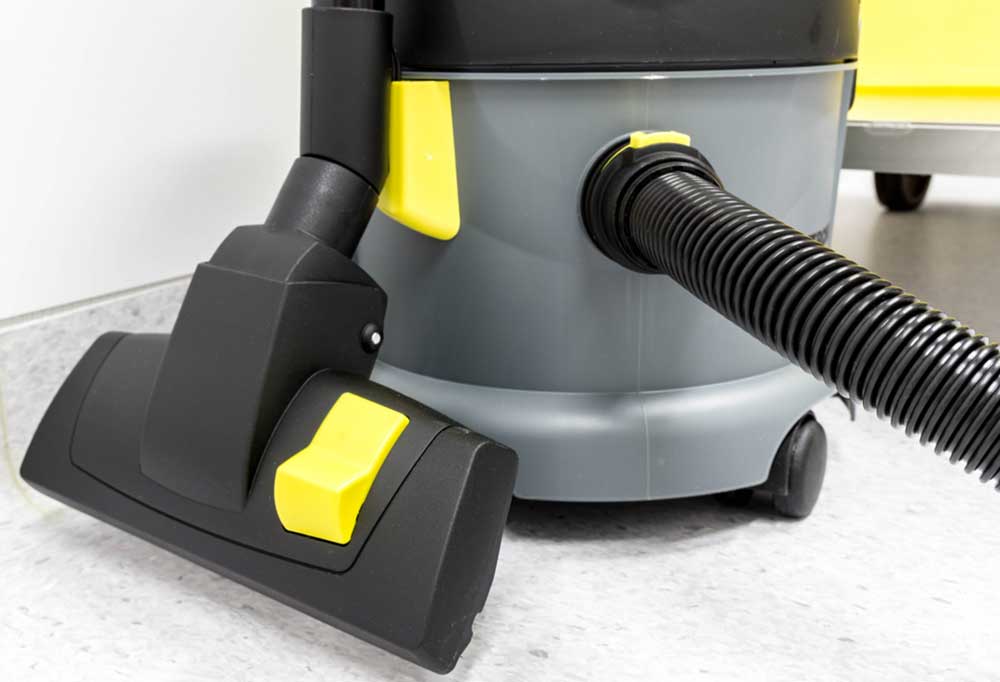 Close up of a grey, black, and yellow  wet/ dry shop vacuum cleaner