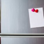 Stainless Steel Fridge with paper held by red heart shaped magnets