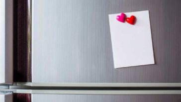 Stainless Steel Fridge with paper held by red heart shaped magnets