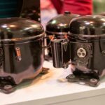 closeups of 3 black fridge compressors