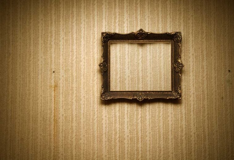Old empty frame hanging on a wall in an old home.