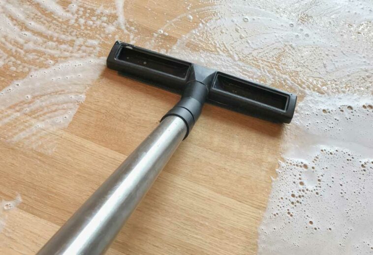 Wet vacuum suctioning water from hardwood floors