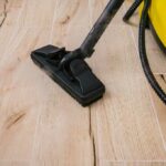 Yellow and black steam cleaner sitting on hardwood floors