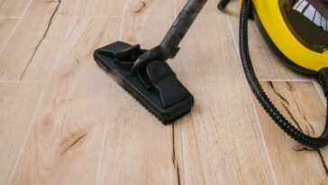 Yellow and black steam cleaner sitting on hardwood floors
