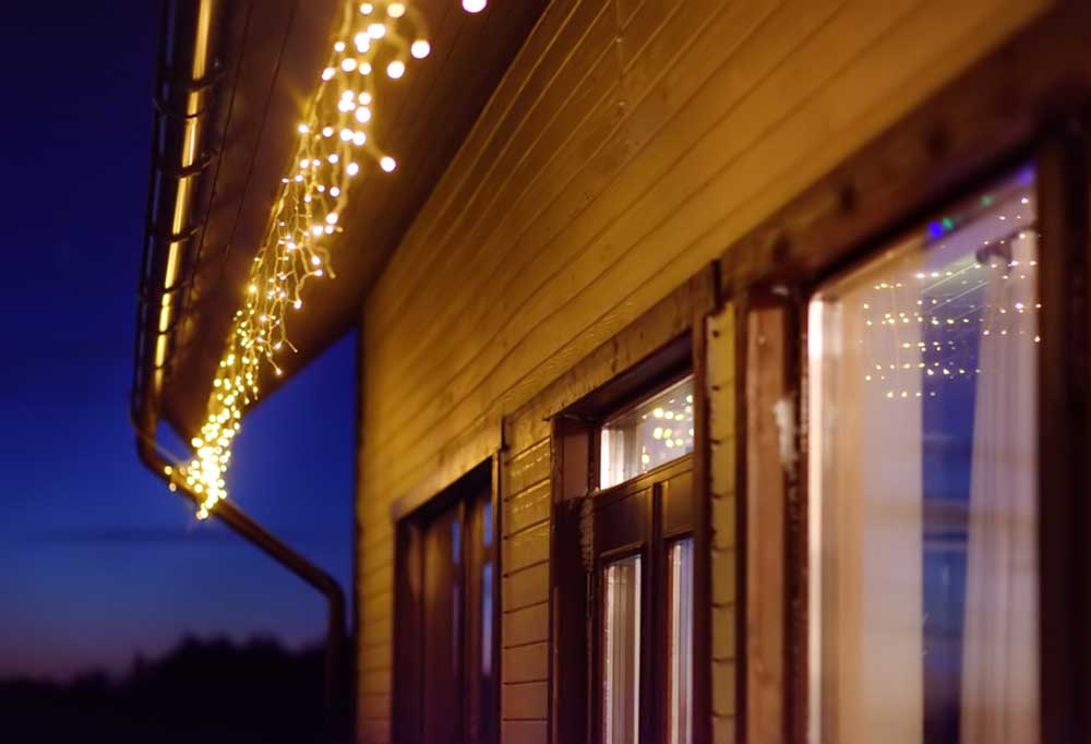 Casa de revestimiento de madera con luces de carámbano colgando del techo