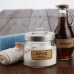 Baking soda, vinegar and dish rags on a wooden table
