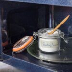 Open glass jar of baking soda in a microwave