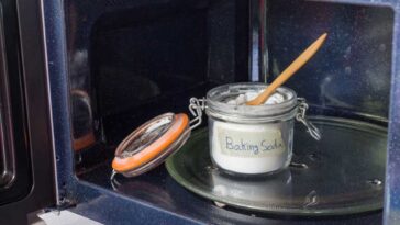 Open glass jar of baking soda in a microwave