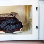 Burnt bag of popcorn in an open microwave