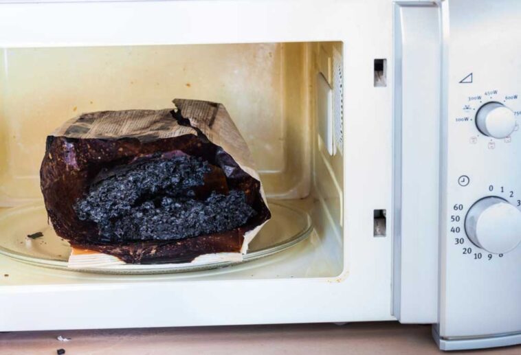 Burnt bag of popcorn in an open microwave