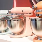 KitchenAid stand mixers lined up on a display, each in a different color