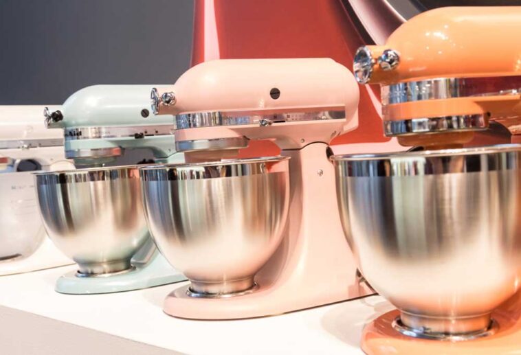 KitchenAid stand mixers lined up on a display, each in a different color