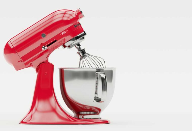 A red KitchenAid mixer with the head tilted back on a white background