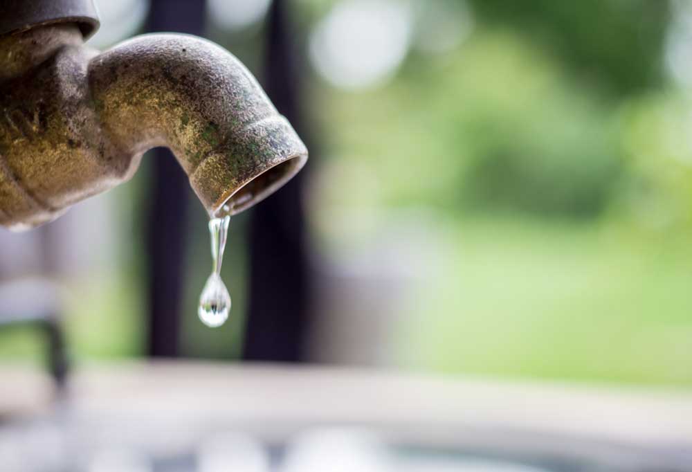 Close up of an outdoor faucet dripping.