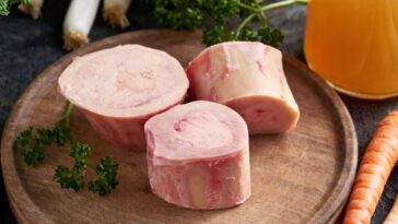 Raw beef bones cut into rounds and sitting on a cutting board