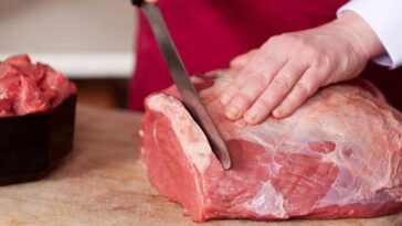 Meat being sliced on a cutting board