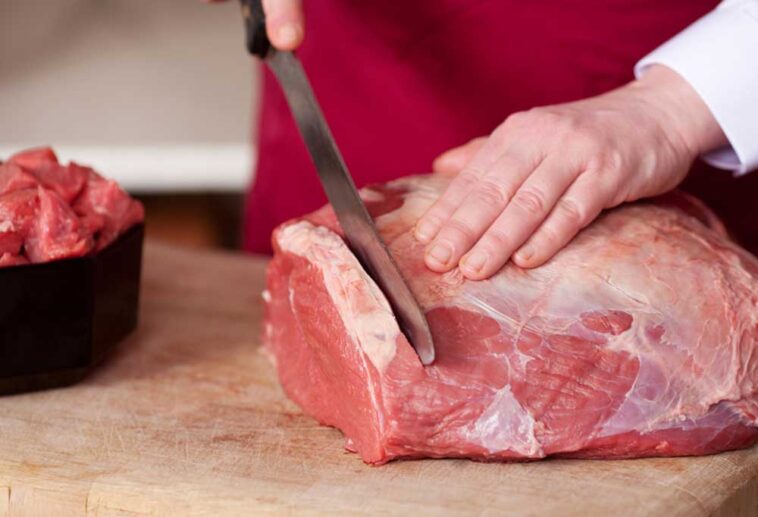 Meat being sliced on a cutting board