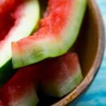 watermelon rinds in a wooden bowl on a blue wood table