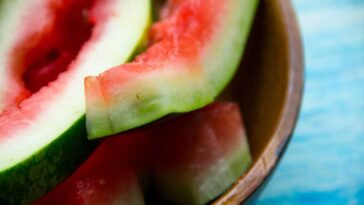 watermelon rinds in a wooden bowl on a blue wood table