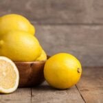 Bowl full of lemons on a wooden table