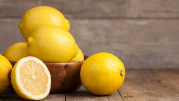 Bowl full of lemons on a wooden table