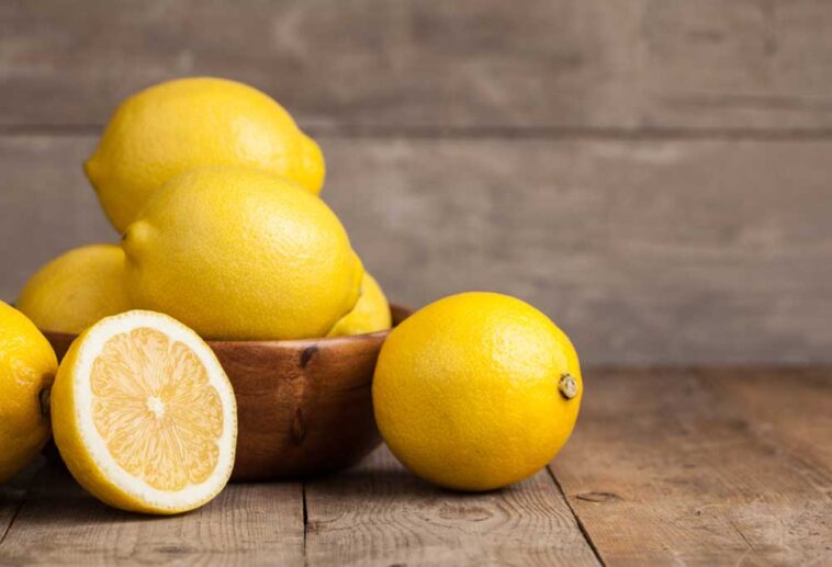 Bowl full of lemons on a wooden table