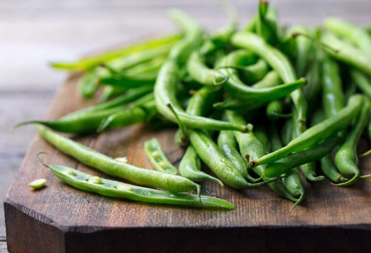 Fresh greenbeans on a wooden cutting board